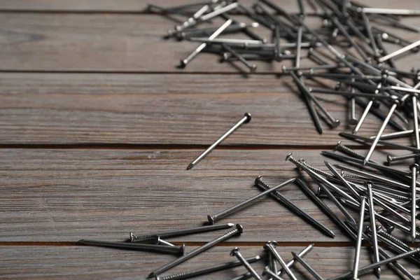 Ahşap masada birçok metal çivi var, yakın plan. Metin için boşluk