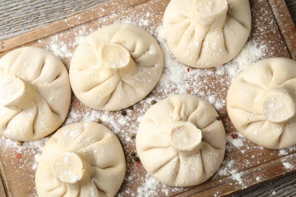 Ahşap masa üzerinde pişmemiş khinkaliler (hamur tatlısı), üst görünüm