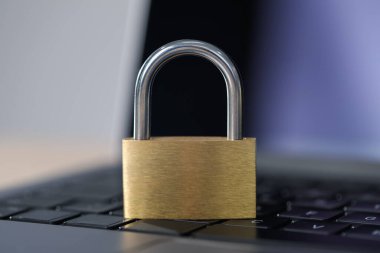 Siber güvenlik. Metal asma kilit ve dizüstü bilgisayar masada, yakın plan.