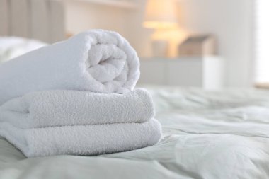 Evdeki çarşafların üzerine yığılmış temiz havlular, yakın çekim. Metin için boşluk