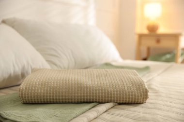 Evdeki çarşafların üzerine katlanmış havlu, yakın plan.