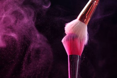 Siyah arka planda pembe göz farlı makyaj fırçaları, yakın plan. Metin için boşluk