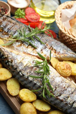 Sofrada baharat ve sebzelerle servis edilen kızarmış uskumrular, yakın plan. Ev yapımı deniz ürünleri yemeği.