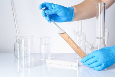 Bilim adamı kirli suyu beyaz masada test ediyor, yakın plan.