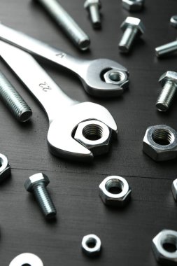 Birçok metal anahtar, cıvata ve somun siyah ahşap masa, yakın plan