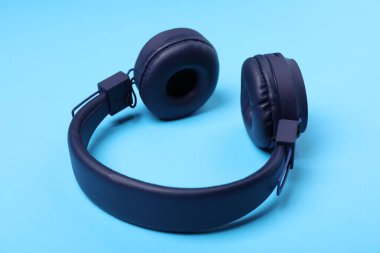 Açık mavi arka planda bir çift şık kulaklık.