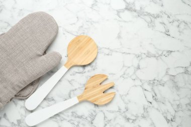 Fırın eldiveni, tutkal ve diğer mutfak aletleri beyaz mermer masada, düz yerde. Metin için boşluk