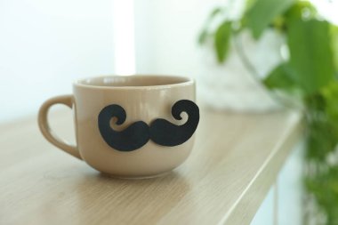 Babalar Günün kutlu olsun. Kapalı masa üzerinde bıyıklı fincan, yakın plan. Metin için boşluk