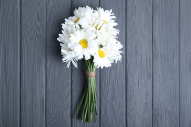 Gri ahşap masadaki güzel papatya çiçekleri.