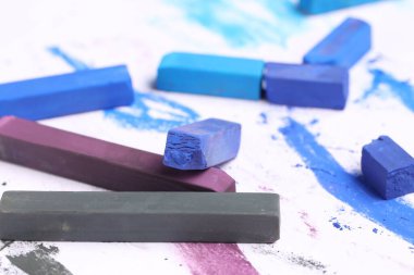 Beyaz arkaplanda renkli tebeşirler, yakın plan