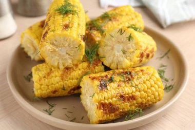 Ahşap masadaki dereotlu mısır koçanları, yakın plan.