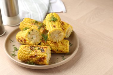 Ahşap masadaki dereotlu mısır koçanları, yakın plan.