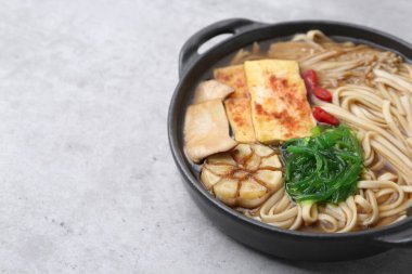 Açık gri masada Enoki ve Kral istiridye (eryngii) mantarlı lezzetli ramen, yakın plan. Metin için boşluk