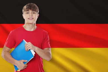Almanya bayrağına karşı not defterleri olan öğrenci. Dil okulu