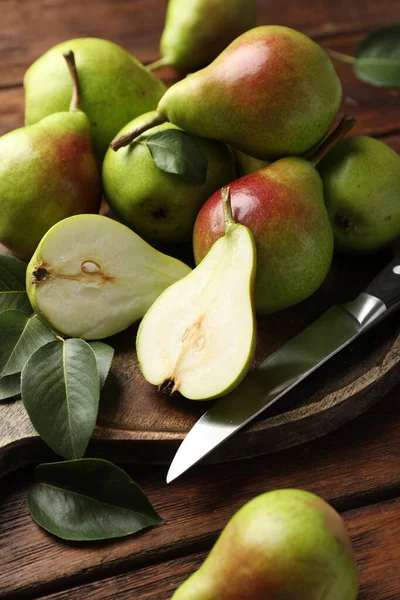 Taze armutlar ve bıçaklar ahşap masada, yakın plan.