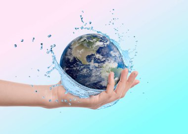 Su kavramını sakla. Yeryüzü, kadının elinde mavi eğimli arka plana doğru su sıçratıyor. Yakın plan.