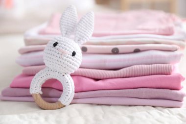 Temiz bebek kıyafetleri ve çarşaflara aksesuar yığını.