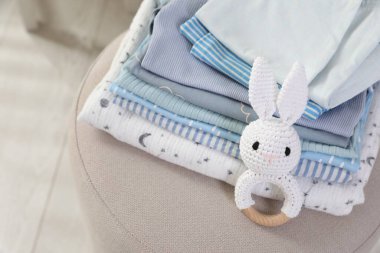 Temiz bebek kıyafetleri ve oyuncak yığını içeride, yukarıda.