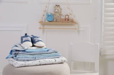 Temiz bebek kıyafetleri ve pouf kapalı yerde ayakkabı yığını, mesaj için yer