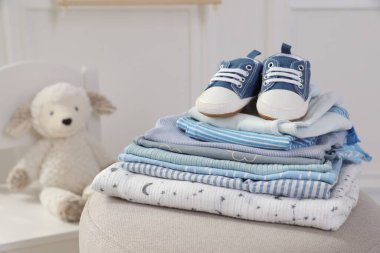 Temiz bebek kıyafetleri ve pouf kapalı yerde ayakkabı yığını, mesaj için yer