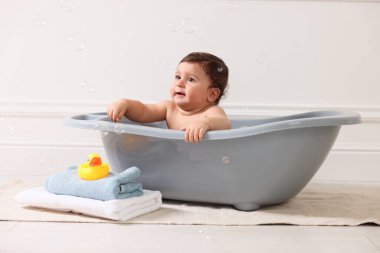 Evde küvette banyo yapan şirin bir bebek.