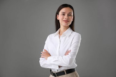 Gri arka planda kendine güvenen bir iş kadınının portresi. Metin için boşluk