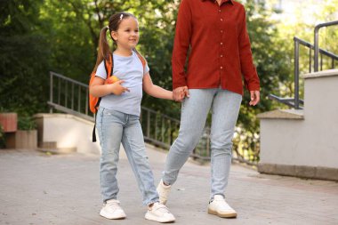 Anne kızını açık hava okuluna götürüyor, yakın çekim.