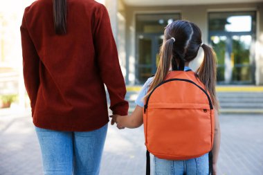 Anne kızını açık hava okuluna götürüyor.