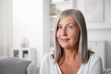 Evdeki kanepede son sınıf öğrencisi zarif bir kadın. Metin için boşluk