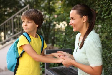 Anne oğlunu açık hava okuluna götürüyor.