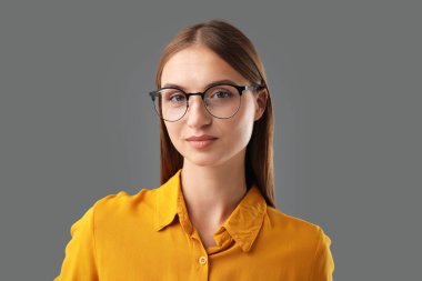 Gri arkaplanda kendine güvenen bir kadının portresi