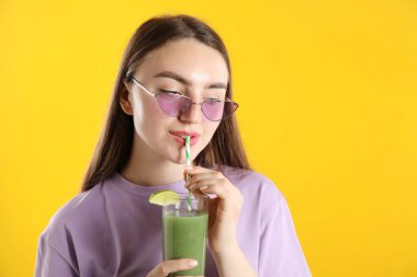 Turuncu arka planda samandan ferahlatıcı içecek içen kadın, mesaj için yer