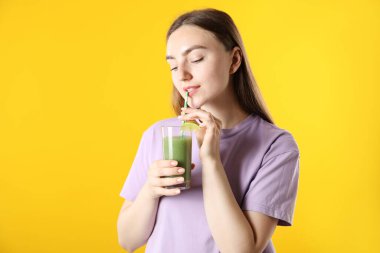 Turuncu arka planda samandan ferahlatıcı içecek içen kadın.