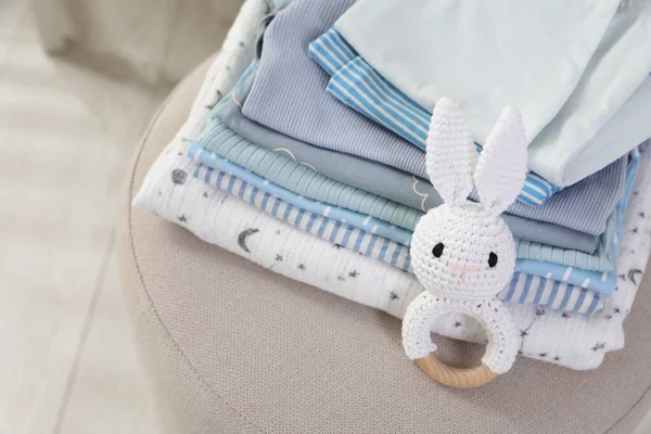 Temiz bebek kıyafetleri ve oyuncak yığını içeride, yukarıda.