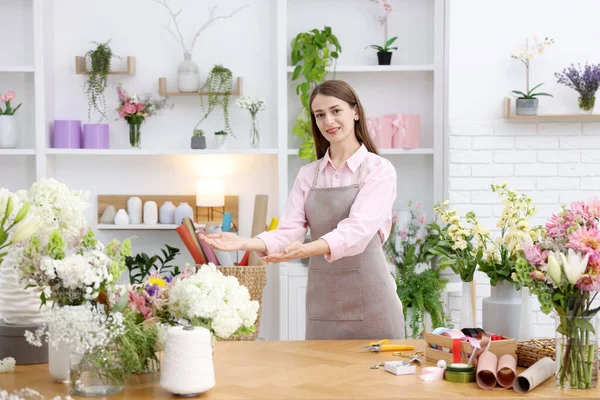 Dükkandaki ahşap masada çalışan profesyonel bir çiçekçi.