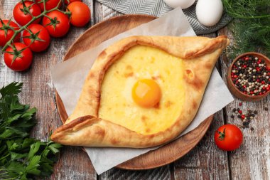 Lezzetli khachapuri peyniri, yumurtası ve diğer ürünleri ahşap masada, düz yatıyordu.