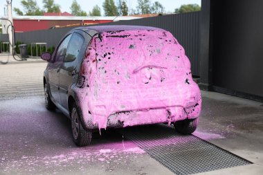 Dışarıdaki oto yıkamada temizleme köpüğüyle kaplanmış.