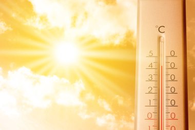 Güneşli bir günde turuncu gökyüzüne karşı termometrede yüksek sıcaklık. Sıcak yaz havası