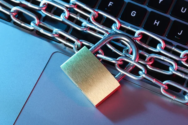 Siber güvenlik. Metal asma kilit, dizüstü bilgisayarda renkli ışıklar, üst görünüm.
