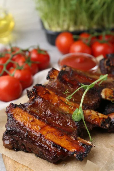 Kızarmış biftek pirzolası, mikroyeşillikler, domatesler ve soslar masada, yakın plan.