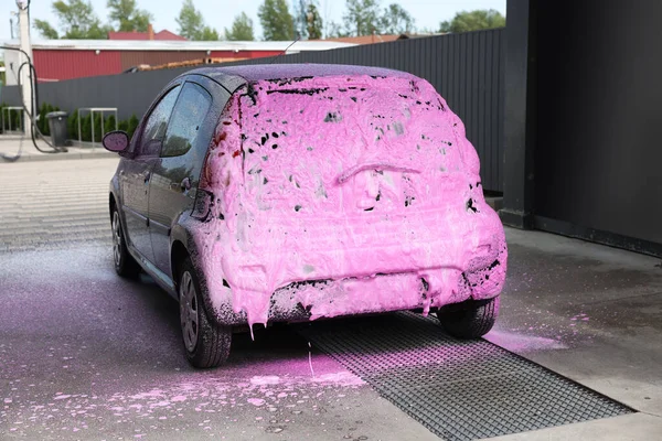 Dışarıdaki oto yıkamada temizleme köpüğüyle kaplanmış.