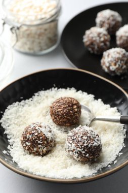 Beyaz masada fındıklı ve hindistan cevizli lezzetli çikolatalar yapmak, yakın plan.