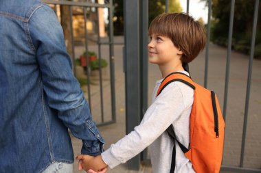 Anne oğlunu açık hava okuluna götürüyor, yakın çekim.