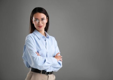 Gri arka planda kendine güvenen bir iş kadınının portresi. Metin için boşluk