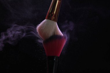 Siyah arka planda mor göz farlı makyaj fırçaları, yakın plan