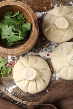 Ahşap masada biber ve maydanozlu pişmemiş khinkaliler (hamur tatlısı).