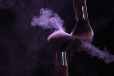 Siyah arka planda mor göz farlı makyaj fırçaları, yakın plan