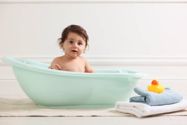 Evde küvette banyo yapan şirin bir bebek.