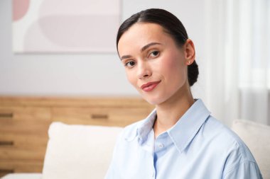 Evdeki kanepede oturan zarif bir kadın. Metin için boşluk