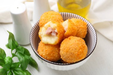 Lezzetli kızarmış köfteler kasede ve baharatlar beyaz ahşap masada, yakın plan.